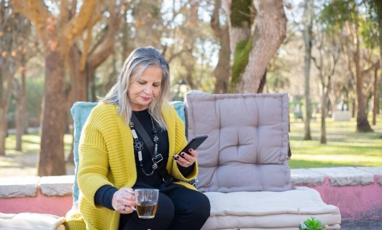 Mujer sonriente y confiada, con un fondo de colores cálidos y naturales, simbolizando la menopausia como una parte natural de la vida.