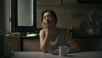 Una taza de café sobre una mesa con un reloj de fondo