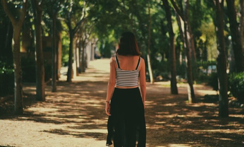 Mujer caminando por un sendero, simbolizando la búsqueda de una vida saludable