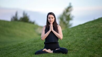 Una persona practicando meditación con los ojos cerrados y las manos en la posición de la oración