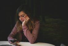 Una persona mirándose al espejo con una expresión de insatisfacción