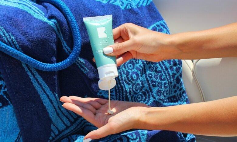 Imagen de una persona aplicando crema solar en la playa