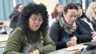 Docentes y estudiantes trabajando juntos en un aula con tecnología