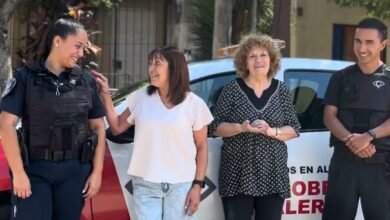 Un policía con una computadora portátil y una persona utilizando el programa Cordobeses en Alerta