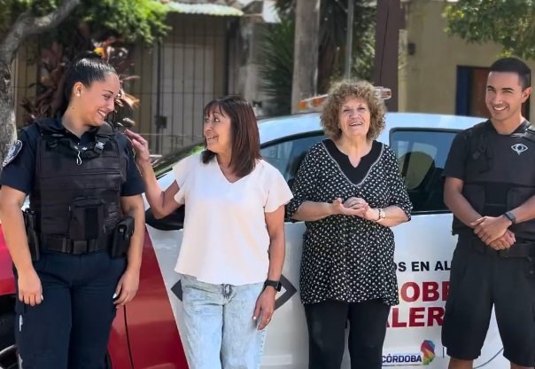 Un policía con una computadora portátil y una persona utilizando el programa Cordobeses en Alerta