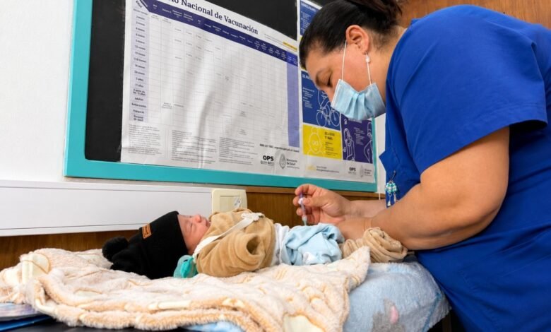Imagen de un recién nacido y un médico con un frasco de vacuna