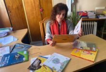 Imagen de un docente cordobés con un libro y un lápiz, rodeado de niños leyendo
