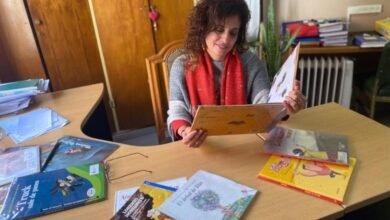 Imagen de un docente cordobés con un libro y un lápiz, rodeado de niños leyendo