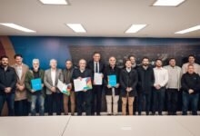 Imagen de un estadio de fútbol con paneles solares y una bandera que dice 'carbono neutral'