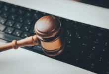 Imagen de un juez y abogados en una sala de tribunal con una pantalla de computadora mostrando el logo de ChatGPT