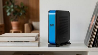 Router de Movistar sobre una mesa con fondo de cables y dispositivos electrónicos