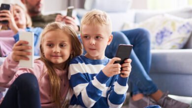 Niños leyendo con teléfonos móviles