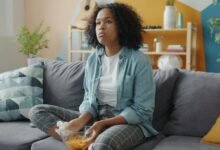Persona sentada en un sofá con una laptop en la mano