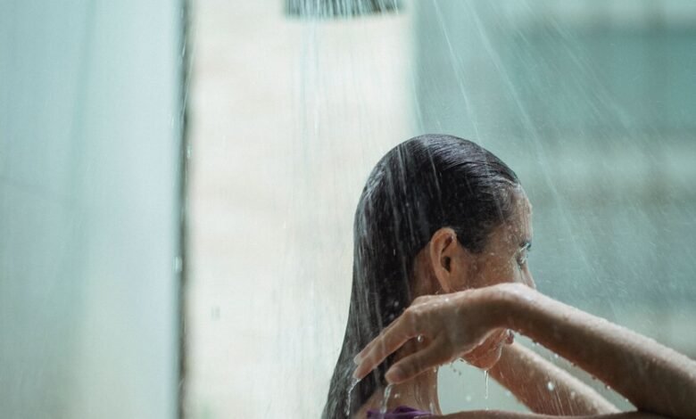 Persona bajo la ducha con agua caliente