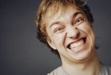 Una persona sonriendo mientras ve a alguien sufrir una desgracia