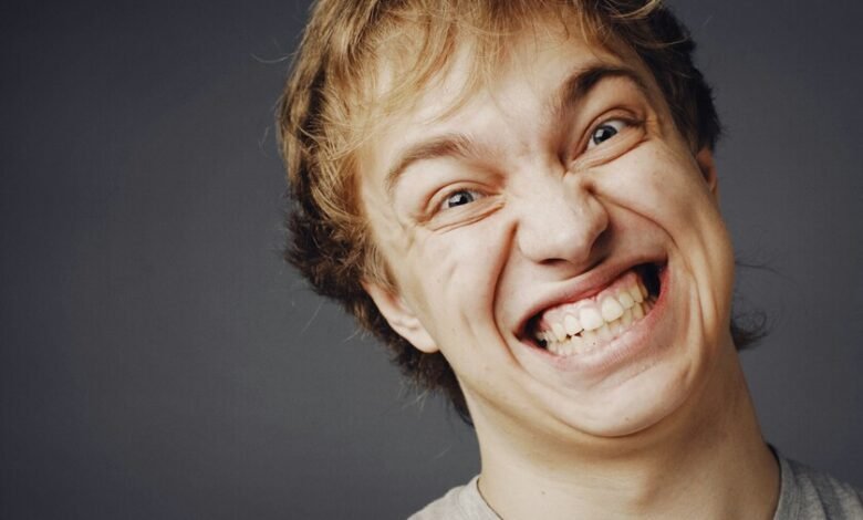 Una persona sonriendo mientras ve a alguien sufrir una desgracia
