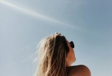 Persona aplicándose crema solar en la playa