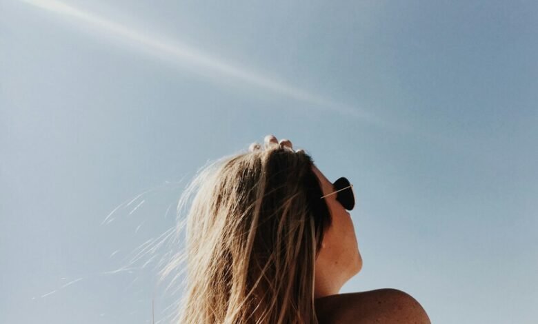 Persona aplicándose crema solar en la playa