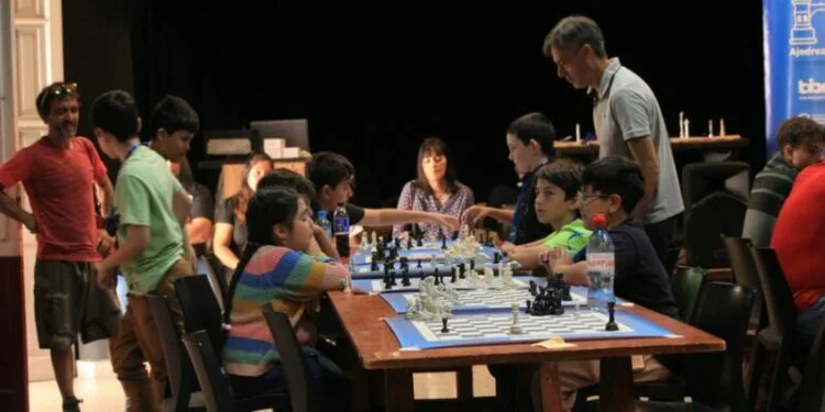 Niños y adultos jugando ajedrez en el Parque de la Biodiversidad