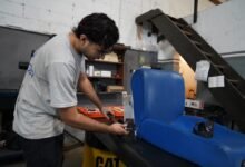 Imagen de una persona trabajando en un escritorio con una laptop y papeles