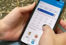 Imagen de una persona usando un teléfono móvil con una aplicación bancaria, con un fondo de cifras y códigos de seguridad