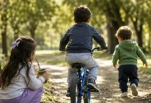 Tres hermanitos sonríen juntos, rodeados de juguetes y colores vivos, simbolizando la alegría y la unión familiar