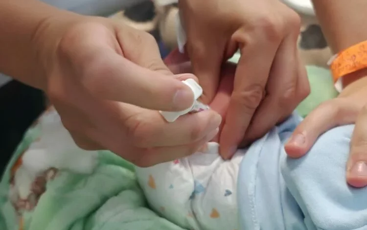 Niño pequeño sonriendo con un médico de fondo