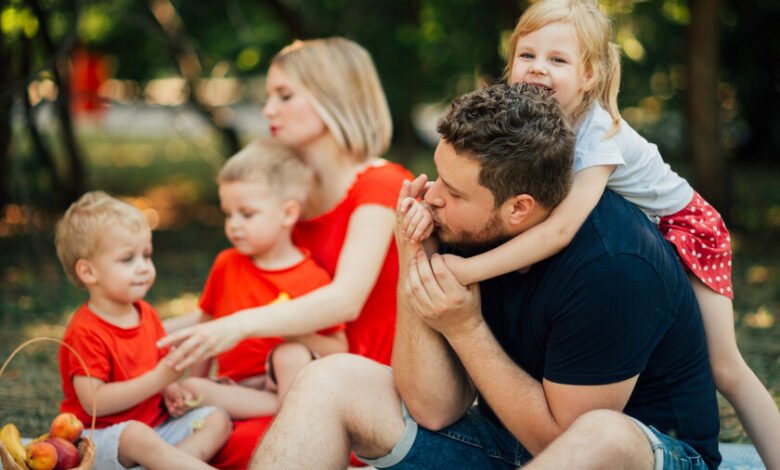 Imagen de una familia sonriente con hijos pequeños, representando la paternidad y la felicidad