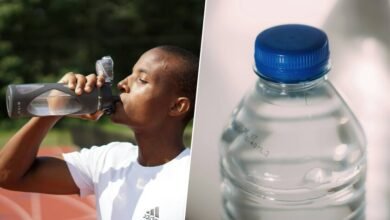 Imagen de una botella de plástico con microplásticos flotando en el agua