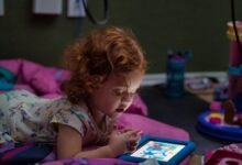 Niños cordobeses usando tabletas mientras estudian, reflejando el debate sobre pantallas y cognición.