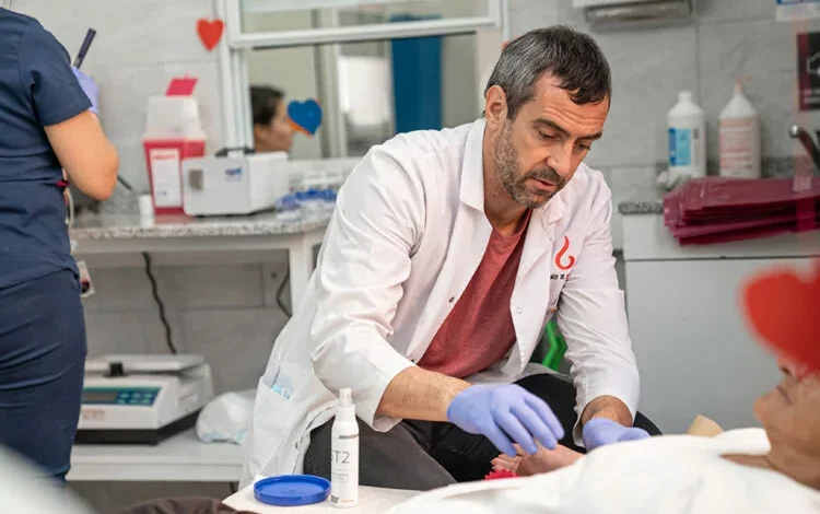 Persona donando sangre en una posta móvil