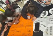 Estudiantes y docentes trabajando juntos con tecnología en el aula