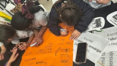 Estudiantes y docentes trabajando juntos con tecnología en el aula