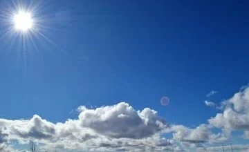 Cielo de Córdoba al atardecer con nubes dispersas y luces de la ciudad