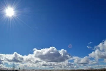 Cielo de Córdoba al atardecer con nubes dispersas y luces de la ciudad