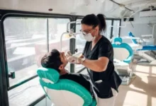 Persona realizando un autoexamen bucal frente al espejo