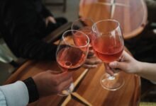 Vino tinto servido en copa sobre mesa de madera