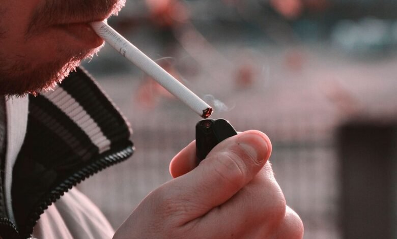 Persona mayor fumando en una terraza, símbolo del vínculo entre tabaco y aislamiento social