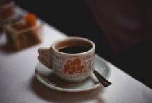 Taza de café humeante sobre mesa de madera