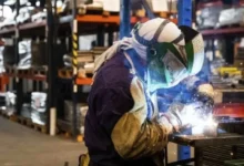 Fábrica metalúrgica en la zona industrial de Córdoba con maquinaria parada y humo saliendo de chimeneas