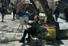 Esther Arrúa, la pintora de la Peatonal, frente a su obra en el Paseo de las Flores