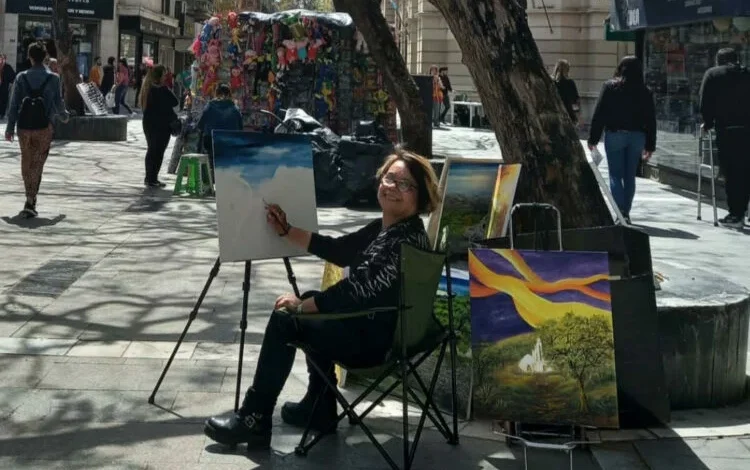 Esther Arrúa, la pintora de la Peatonal, frente a su obra en el Paseo de las Flores