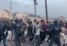 Policía nacional y Guardia Civil controlando el traslado de migrantes al campamento del puerto de Ceuta