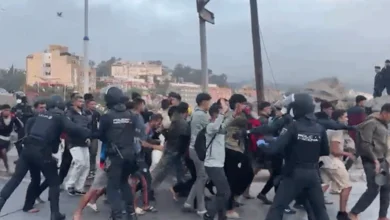 Policía nacional y Guardia Civil controlando el traslado de migrantes al campamento del puerto de Ceuta