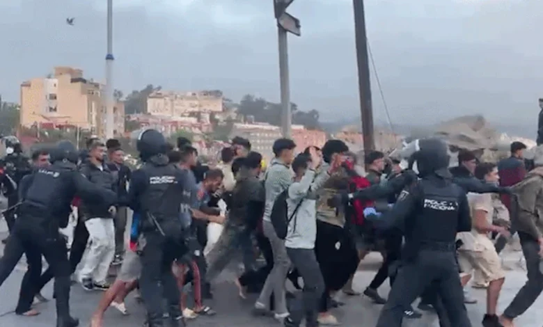 Policía nacional y Guardia Civil controlando el traslado de migrantes al campamento del puerto de Ceuta