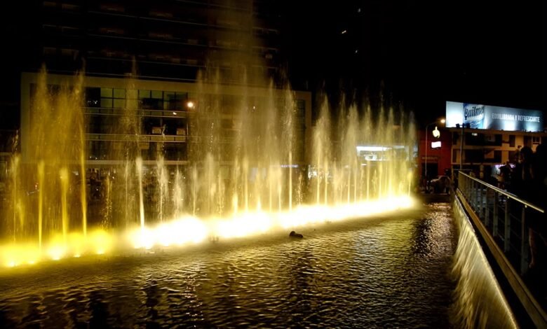 Fuente del Buen Pastor iluminada al anochecer con chorros de agua sincronizados a la música