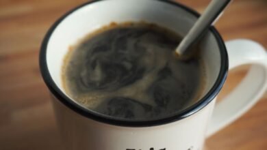 Taza de café humeante sobre una mesa de madera