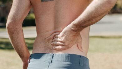 Persona con dolor de espalda sosteniendo la zona lumbar
