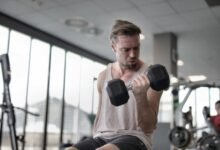 Entrenador de fuerza en gimnasio con pesas y cardio