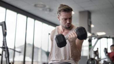 Entrenador de fuerza en gimnasio con pesas y cardio